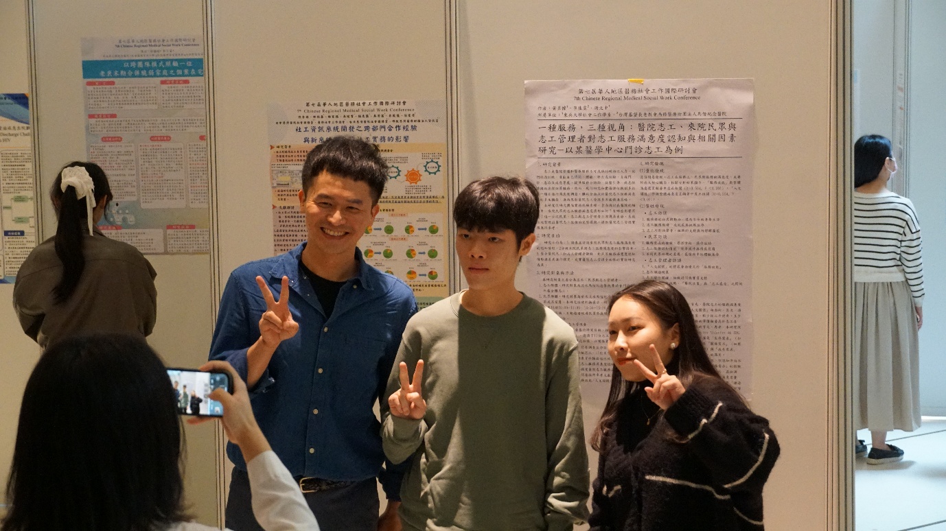 會場設置海報展示區,與會工作者於海報前合影留念。