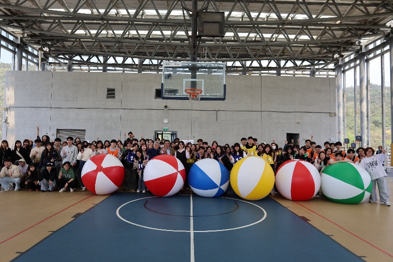 實踐大學校慶系列活動「系學會滾大球比賽」圓滿落幕，校長學生齊聚體育館五樓大合照，展現團結合作與青春洋溢的精彩時刻。