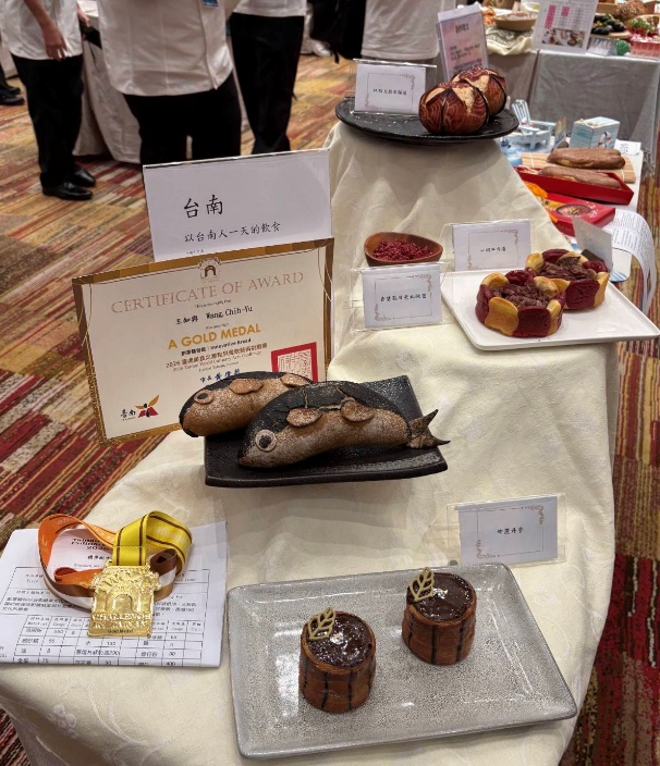 王知與同學以「臺南－以台南人一天的飲食」為主題，結合在地飲食文化與創意烘焙技術，作品包含魚形麵包及多款特色造型烘焙作品，榮獲2026臺南美食之都世界餐飲藝術挑戰賽金牌。